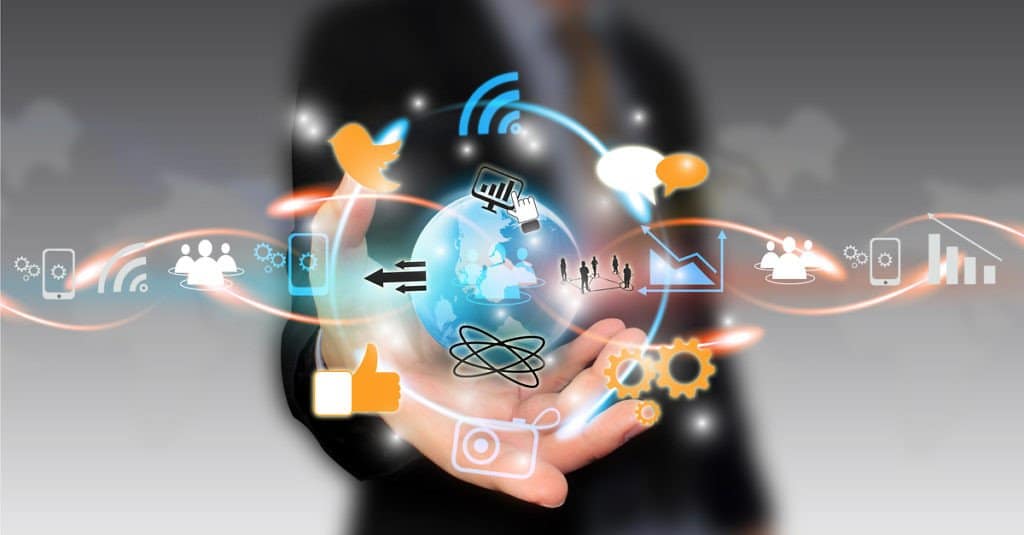 Hands holding globe with floating tech and social media icons, symbolizing global connectivity.