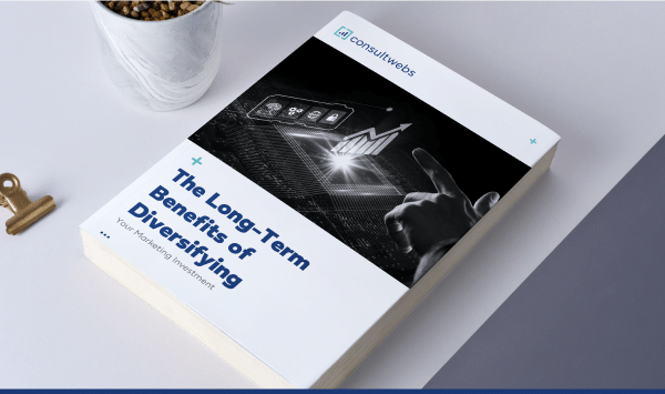 Book on investment diversification next to a plant in a mug, symbolizing growth and potential.