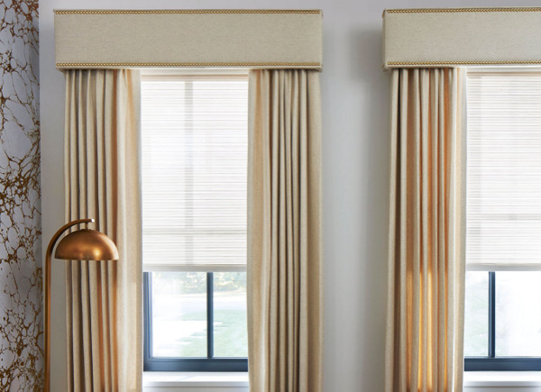 A  living room with large windows dressed with Drapery and Cornices with Nailheads.