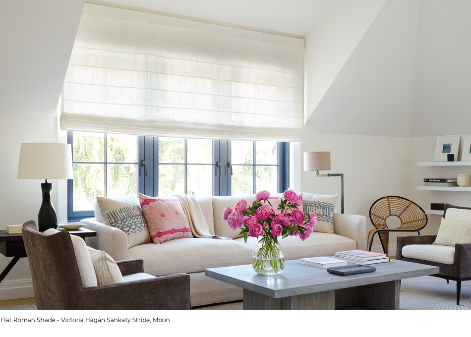 Flat Roman Shade in Sankaty Stripe material and Moon color featured over large windows with black frame in a sitting area