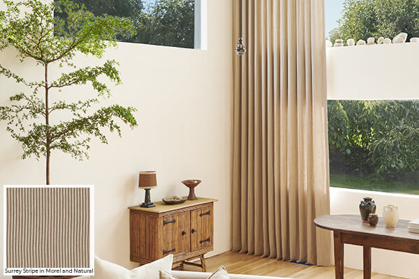 Brown drapery, like Surrey Stripe in Morel and Natural seen here in a living room, is one of the best window drape ideas of 2026