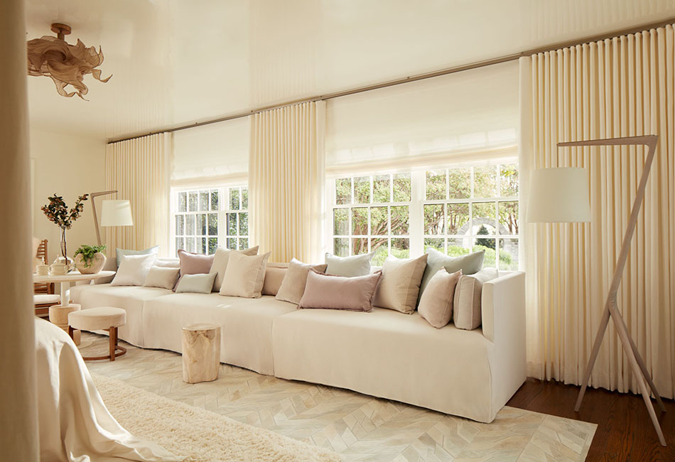 Modern living room curtain concept in a soft monochrome design pairs Ripple Fold Drapery with woven shades for layered texture.