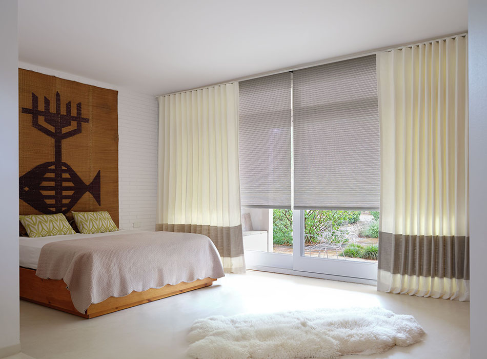 A boho chic bedroom featuring Luxe Linen Ripple Fold Drapery in Oyster and Flax used as a sliding glass door curtain.