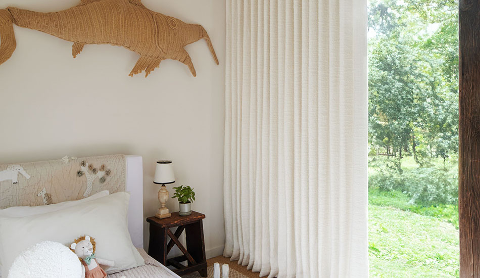 Light colored drapery like Claude Stripe in Alabaster in a kid's room is a good choice for curtains to keep heat out.