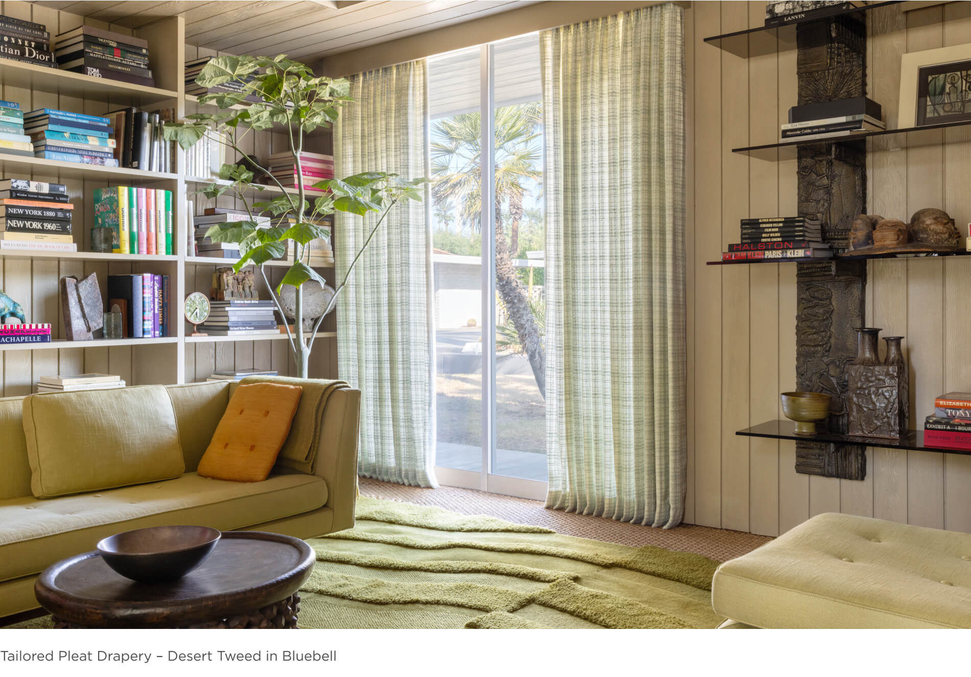 A quiet living room corner features tailored pleat drapery featuring Martryn Lawrence Bullard's Desert Tweed in Bluebell