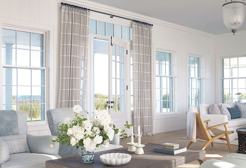 An example of living room curtain ideas in a bright coastal-inspired space with striped drapes