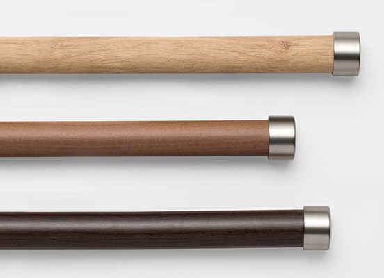 Three drapery hardware options in various Tribeca finishes laid out on a white table top