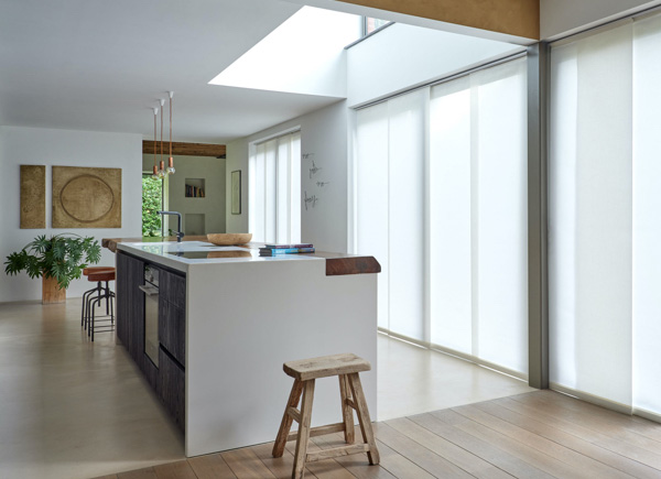 Large patio doors featuring vertical blinds in park winter white hung in an open kitchen with a large white centered island