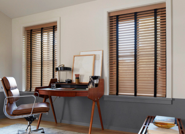 An office with a wooden desk and windows dressed with Oak Wood Blinds.