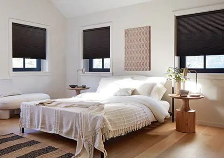 A modern bedroom features privacy shades in a Cellular Shade style made of Single Cell Blackout material in Midnight for energy-efficient window treatments and privacy