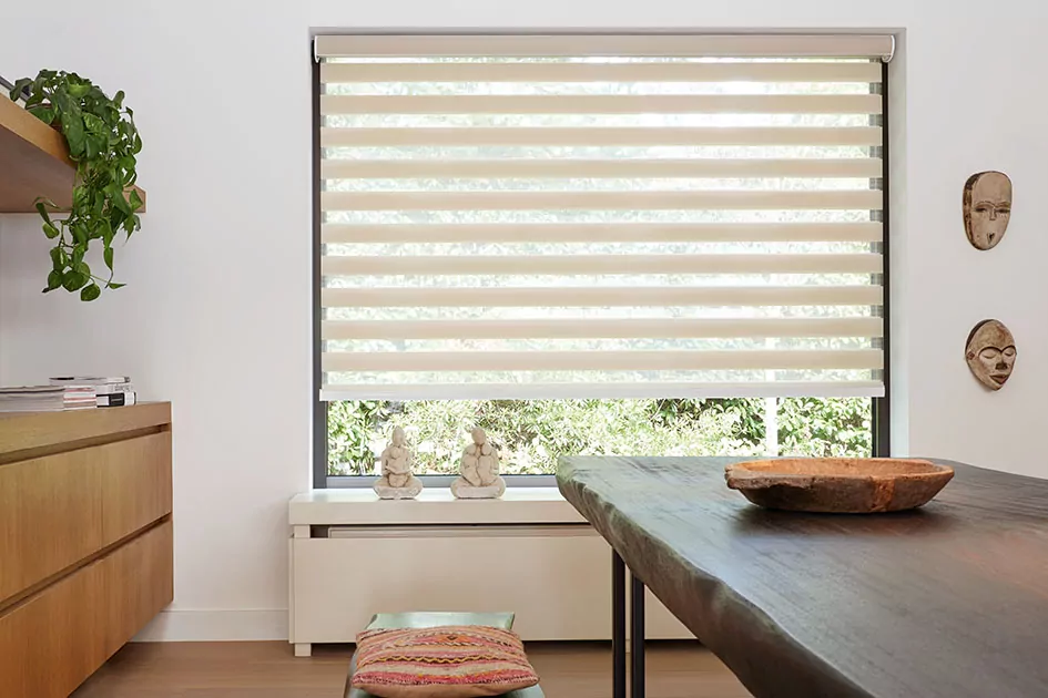 Mid century modern blinds include beige double roller shades in a dining room with a rustic wood dining table