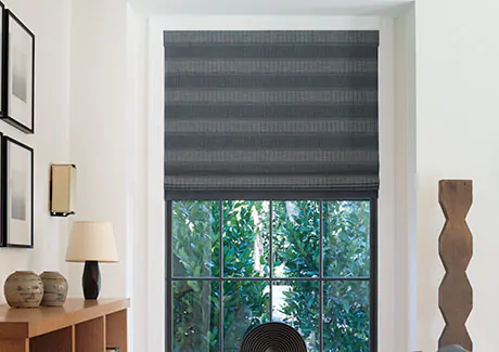 A modern space with wood decor features a Flat Roman Shade made of Jasmine in Midnight, an example of how to install Roman Shades inside mount