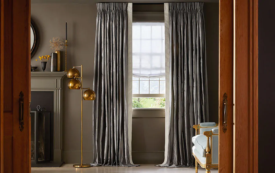Pinch Pleat Drapery in Silk Dupioni Pewter in a luxe living room, showing how long curtains should be for puddle length.