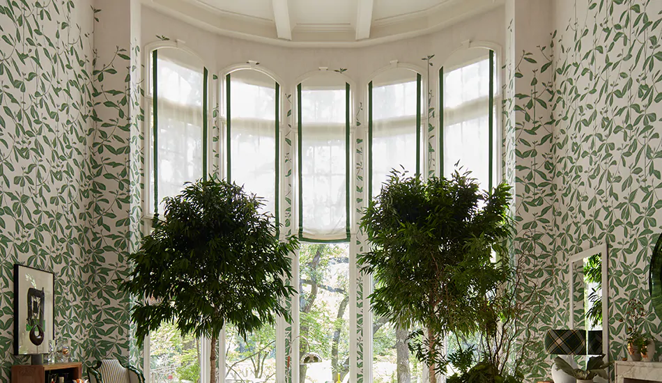 Relaxed Roman Shades made of Linen in White are used in place of blinds for a bay window on tall windows in a luxurious room