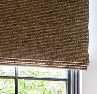 A close-up of a Woven Wood Shade made of Beacon in Cinder with blackout lining shows no light filtering through