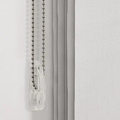 A close-up image of a cord draw system with the cord loop held in a tension device installed on the wall, showing how to close window blinds