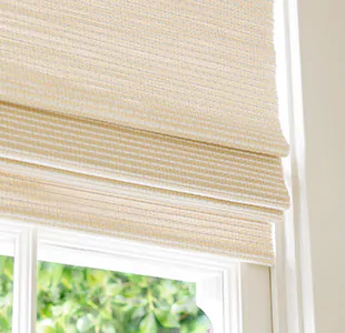A close-up of a Woven Wood Shade made of Somerset in Cloud with privacy lining shows some light filtering through