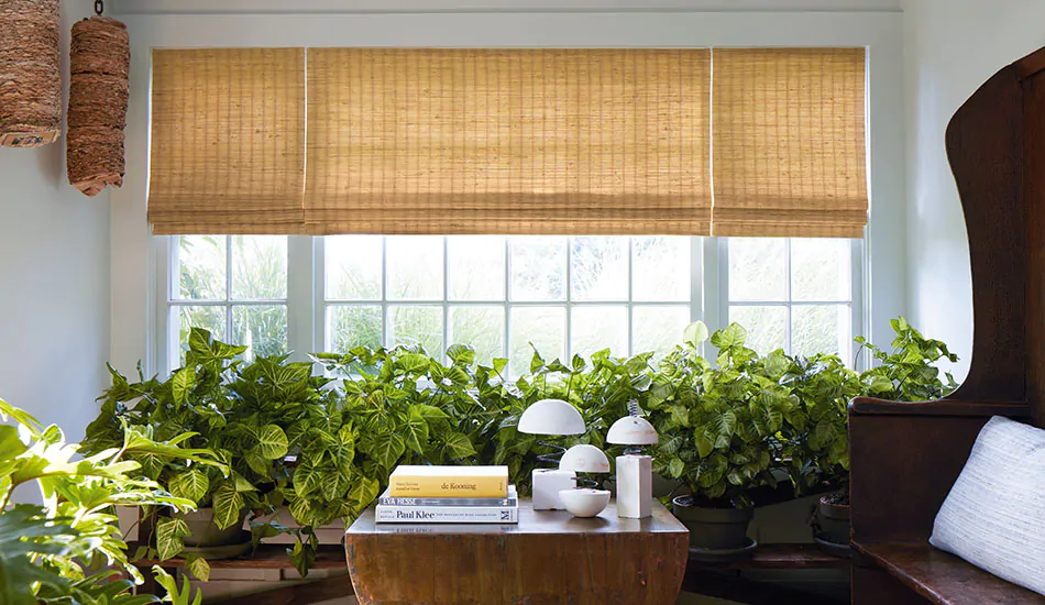 Modern shades with a woven wood design in an inviting sunroom include golden toned waterfall woven wood shades made with natural fibers