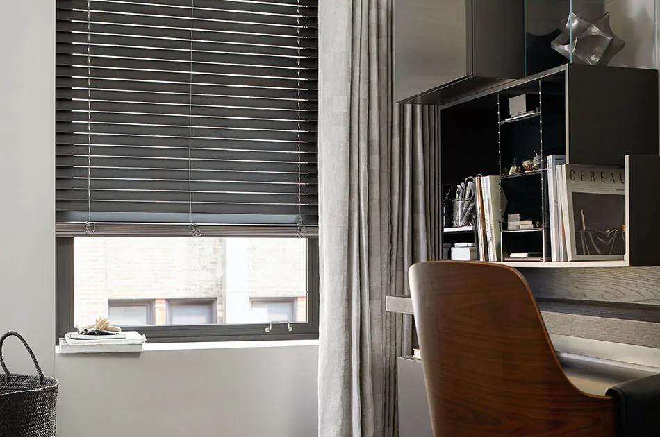 Office with wood blinds on a tall window, highlighting types of window shades and blinds with durable slat design and adjustable light control